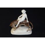 Porcelain figure of a child riding on the back of a leopard