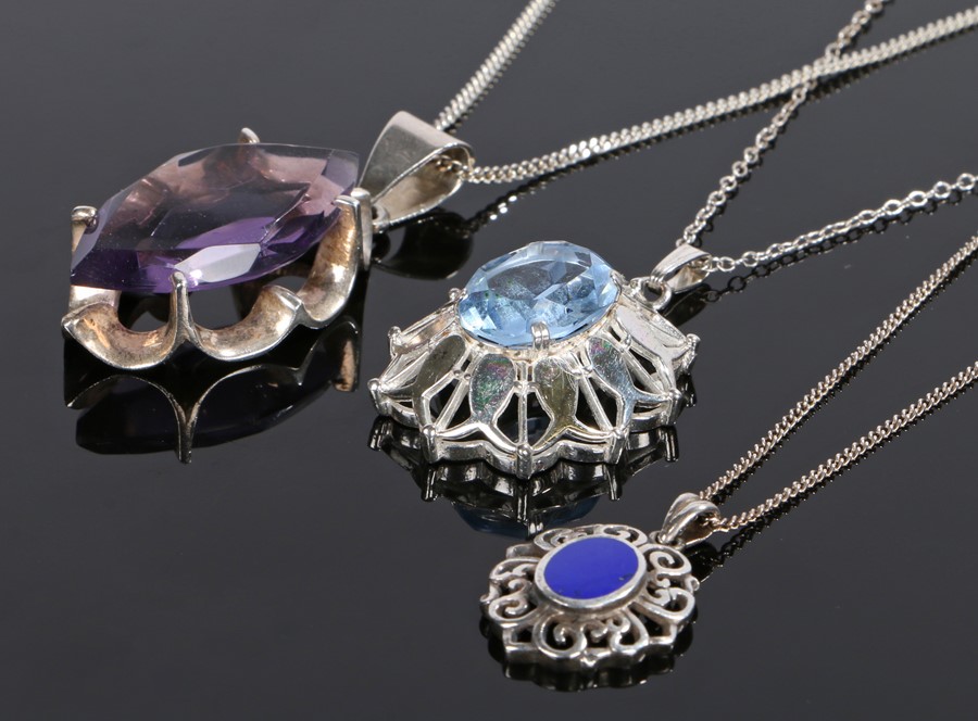 Silver pendant necklaces, the purple navette stone with claw mount, together with a flower design