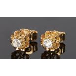 Pair of diamond set earrings, with a central diamond to each set to flower designs, a total