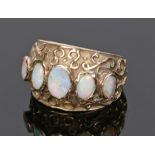 9 carat gold opal set ring, with a row of five opals to the wide head, 4.8 grams, ring size L