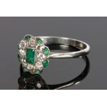 Art Deco white metal diamond and emerald set ring, the central baguette cut emerald with diamond and