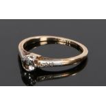18 carat gold diamond set ring, with a round cut diamond flanked by further diamonds to the