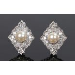 Pair of 18 carat white gold pearl and diamond set earrings, the central pearl with a diamond