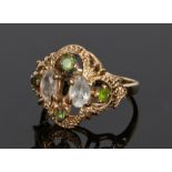 Yellow metal ring, set with peridot round cut stones and pale purple stones to the arch design head,