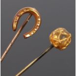 15 carat gold horse shoe stick pin, together with another stick pin and a stick pin case, (3)