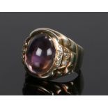 Amethyst and diamond set ring, the central cabochon amethyst flanked by diamonds to the shoulders,