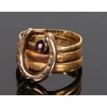 18 carat gold and garnet set horse shoe ring, with a horse shoe to the front and garnet above set to