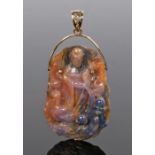 Chinese hardstone pendant, carved with a standing figure among flowers, with an attached pendant