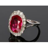 Diamond and simulated ruby ring, the simulated ruby held within a round cut diamond surround to