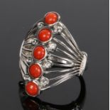 Silver and coral ring, with a row of five round coral beads to the wide hide, ring size Q