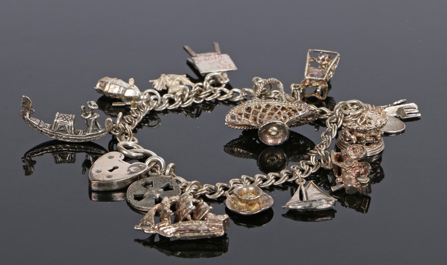 Silver charm bracelet, with various charms and a padlock clasp, 20cm long
