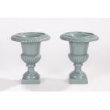 Pair of cast iron urns, with broad tops above a vase and gadrooned base, 22cm high, (2)