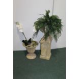 Reconstituted stone effect twin handled urn, containing a faux fern, on a separate plinth base,