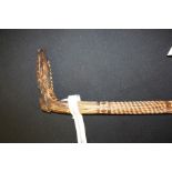 African tribal stick, the handle carved in the form of a shoe, with diamond and line carved shaft,