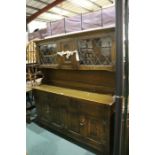 Oak dresser, with central arched panelled section flanked by two lead glazed doors, open recess to