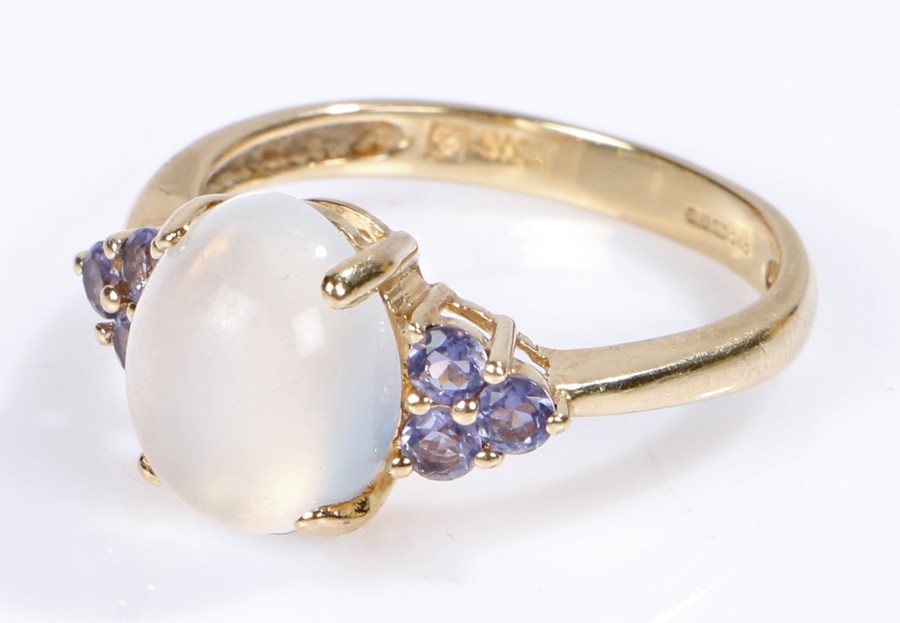 9 carat gold moonstone set ring, the cabochon cut moonstone with purple stones to the sides, 3