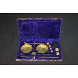 Set of brass balance scales and weights, housed in a blue velvet lined case