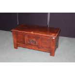 Georgian style oak coffer, the hinged lid above three panels, the central panel with carved stylised