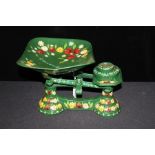 Set of barge ware style scales and weights, with painted floral decoration on a green ground