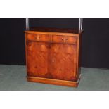 Walnut veneered side cabinet with two dfrieze drawers above two cupboard doors, on a plinth base,