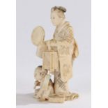 Japanese Meiji period ivory okimono, carved as a standing lady holding a fan above a boy seated on