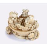 Japanese Edo period ivory netsuke, figures seated in a bowl playing instruments and drinking above