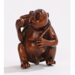 Japanese carved netsuke, as a monkey eating fruit, signed to the base, 4.4cm high