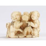 Japanese Meiji period ivory netsuke, carved as a father and child playing with a puppy, 4cm wide