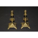 Pair of brass candlesticks, with scroll cast sconces and stems, raised on scroll and foliate cast