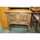 Old Charm oak cabinet, with two linen fold panelled cupboard doors, raises on turned supports and