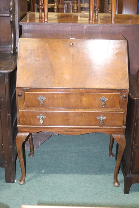 Walnut veneered bureau, the fall opening to reveal a pigeonholed interior, two long frieze