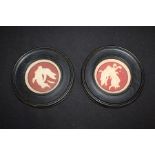 Pair of bisque porcelain wall plaques, the red grounds with raised depictions of cherubs and angels,