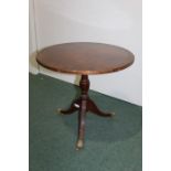 Walnut veneered circular occasional table, on vase shaped stem reeded tripod legs and brass paw