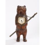 Carved Black Forest clock, of a standing bear holding a copper staff and a clock to the chest,