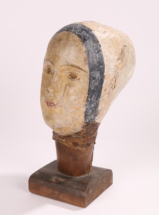 19th Century French papier mache mannequin head, near life size raised on a plinth base, 34cm high