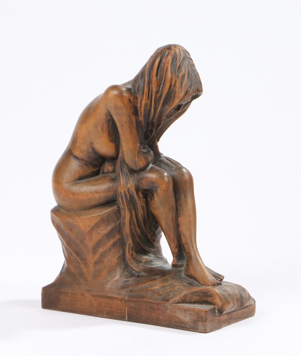 Carved wooden figure, depicting a seated female nude with her head wrapped in a shawl, 21cm high