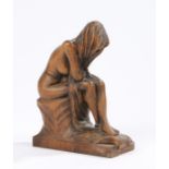 Carved wooden figure, depicting a seated female nude with her head wrapped in a shawl, 21cm high