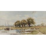 E.D.M. Sailing boat moored on a bank with trees and distant buildings, signed watercolour, dated