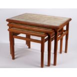 Nest of three mid 20th Century occasional tables, with tile inset tops to the teak frames, raised on
