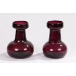 Pair of Victorian purple glass hyacinth vases, with circular tops above a oval mallet shape base,