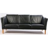 Stouby ash and beech three seat settee, with black leather cushions, curved show wood arms, raised
