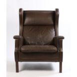 Late 20th Century brown leather wing back armchair, raised on square legs