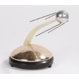 Novelty Russian clockwork musical model commemorating the launch of Sputnik 1957, on a black plastic