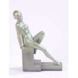 Art Deco style figure, depicting a female nude seated on a stepped square pillar, 30cm high,