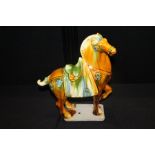 Tang Dynasty style horse, in tan and green glaze, 30cm long