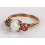9 carat gold ring the pierced shoulders to the head set with a central opal and two garnets ring