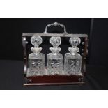 20th century mahogany silver plate three bottle tantalus. 27cm high.