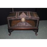 Chinese coffer, with a figural carved scene to the lid above scroll legs, 89cm wide