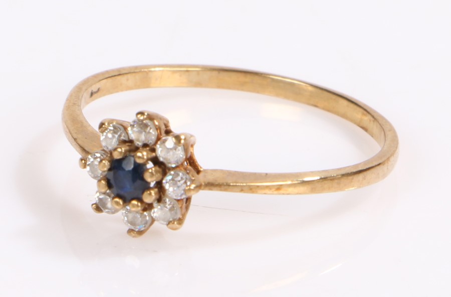 9 carat gold ring, with a central sapphire and flower head design, ring size Q