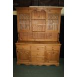 Pine dresser and rack, the astragal glazed rack above the base with a series of cupboards and